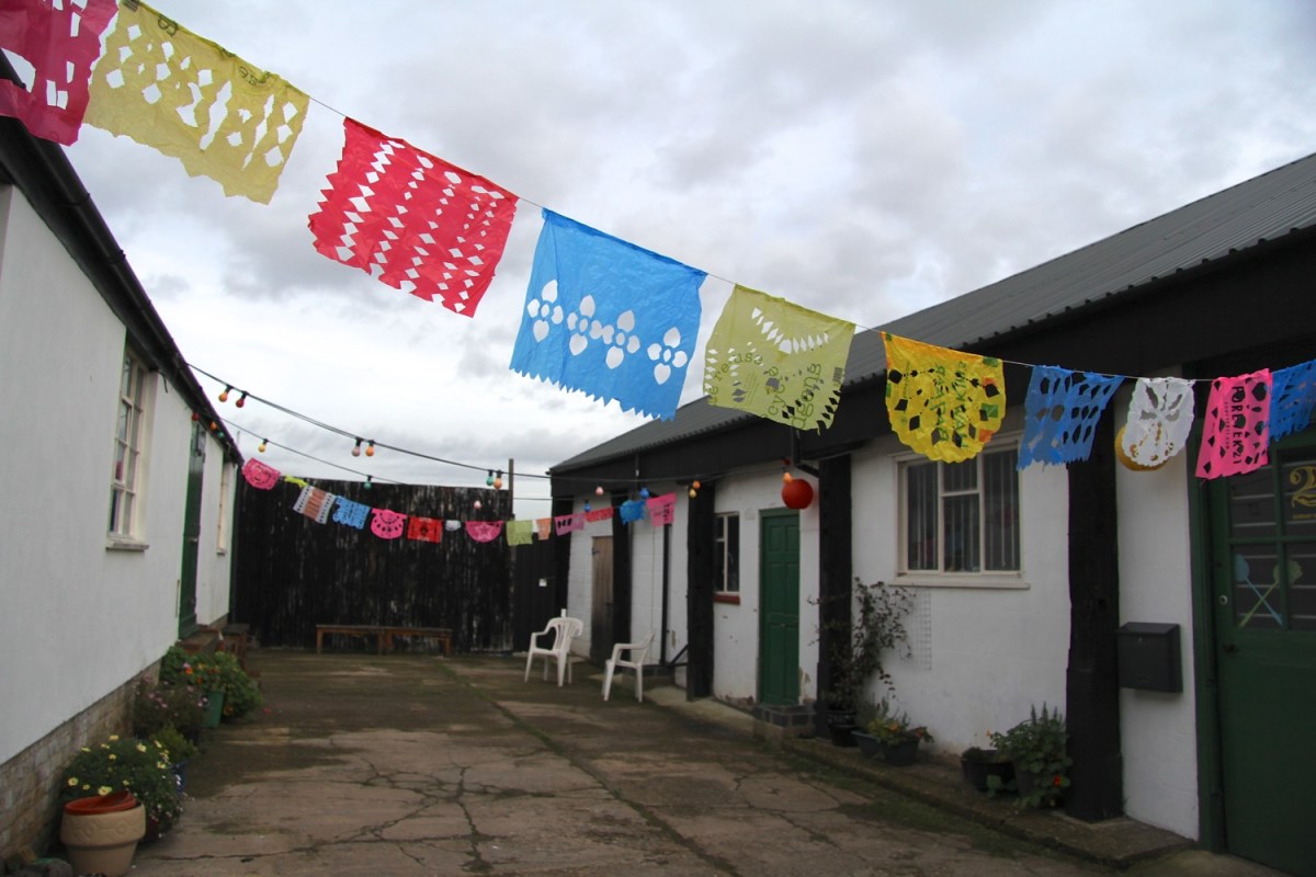 Colourful papel picado banners strung across the Boundary Wharf courtyard