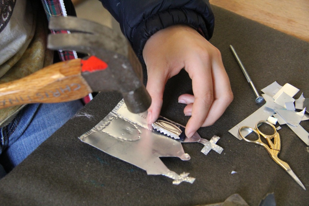 Mexican style tin decoration being made in the shape of a church