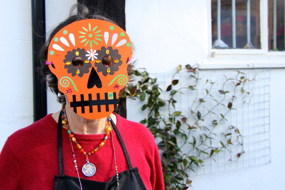 Woman wearing a day of the dead skull mask outside the studios