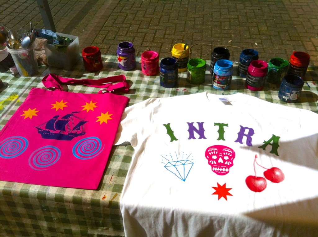 tote bag printed with a ship and t-shirt printed with INTRA and assorted designs